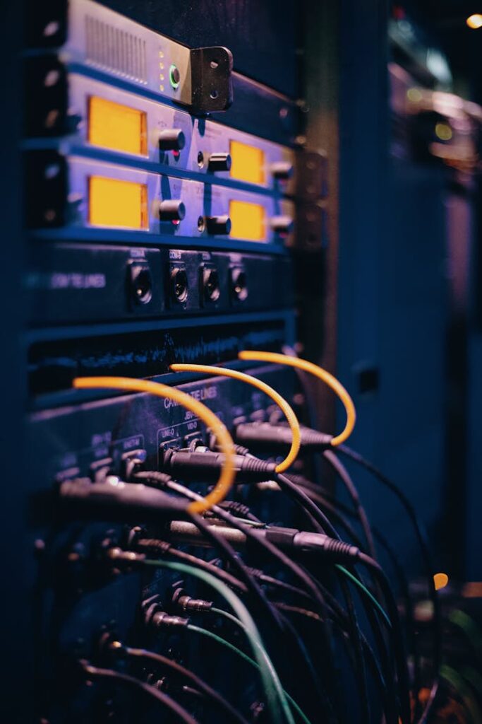 pexels-photo-1054397 Close-up of network cables and ports in a server rack, showcasing connectivity.